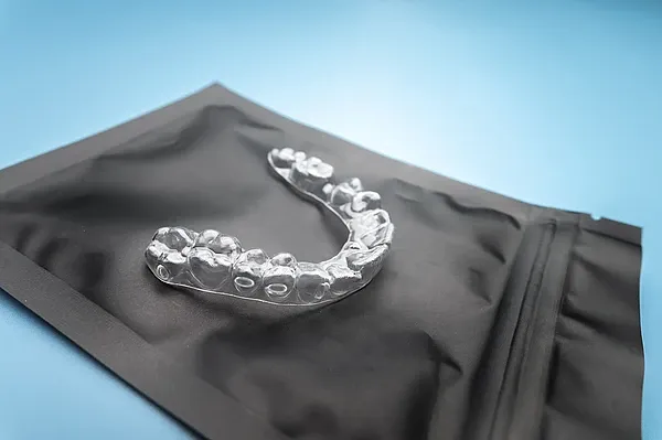 Transparenter Invisalign Aligner auf einer Produktverpackung.