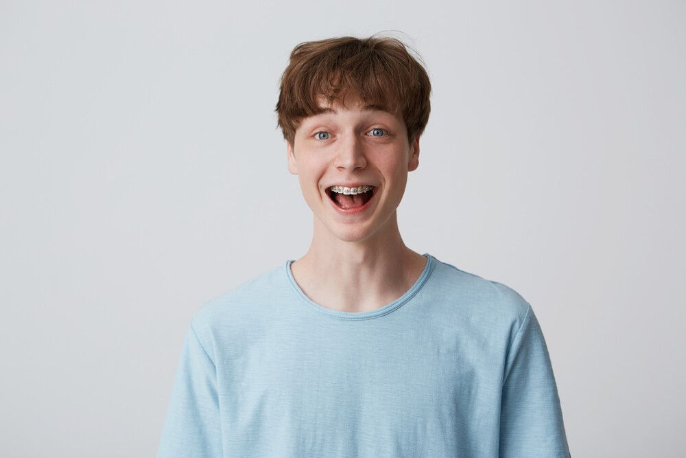 people, male, man, guy, short, disheveled, hair, young, youth, 20's, european, braces, teeth, appearance, copyspace, isolated, white, studio, background, indoor, dressed, blue, casual, tshirt, looks, directly, camera, portrait, closeup, cute, happy, nice, kind, student, teenager, attractive, standing, feels, natural, unconstrained, informal, easy, emotions, expression, amazed, excited, surprised, shouting